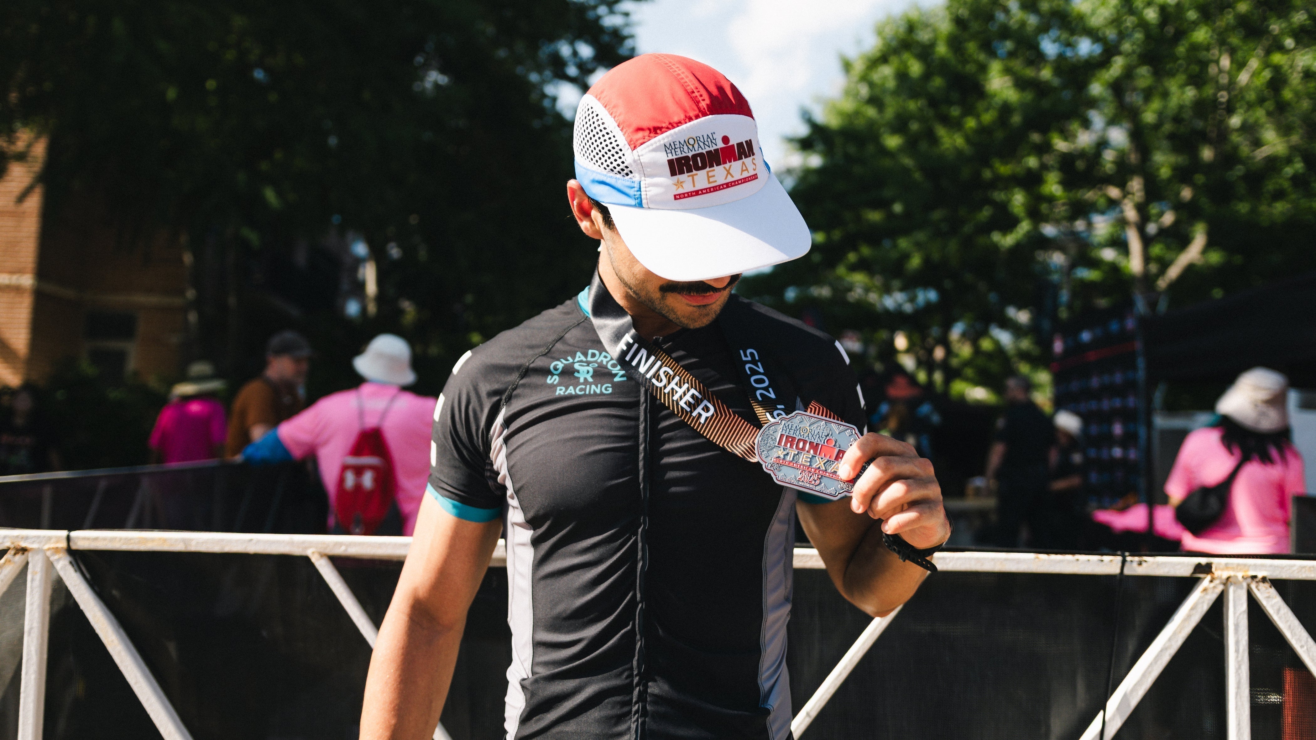 Triathlete holding medal after an Ironman triathlon race.
