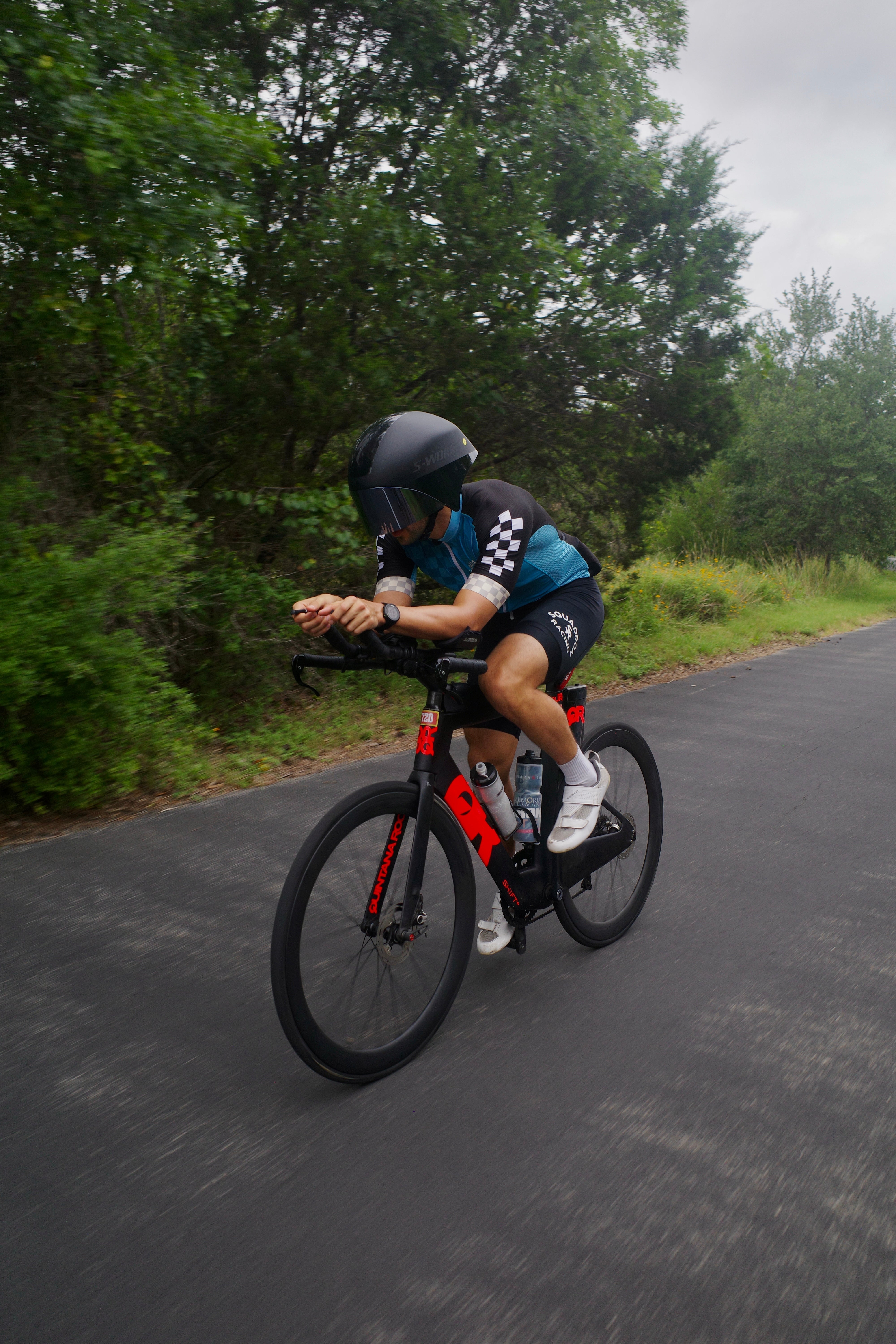 Triathlete in a Squadron Racing cycling kit riding a tri bike.