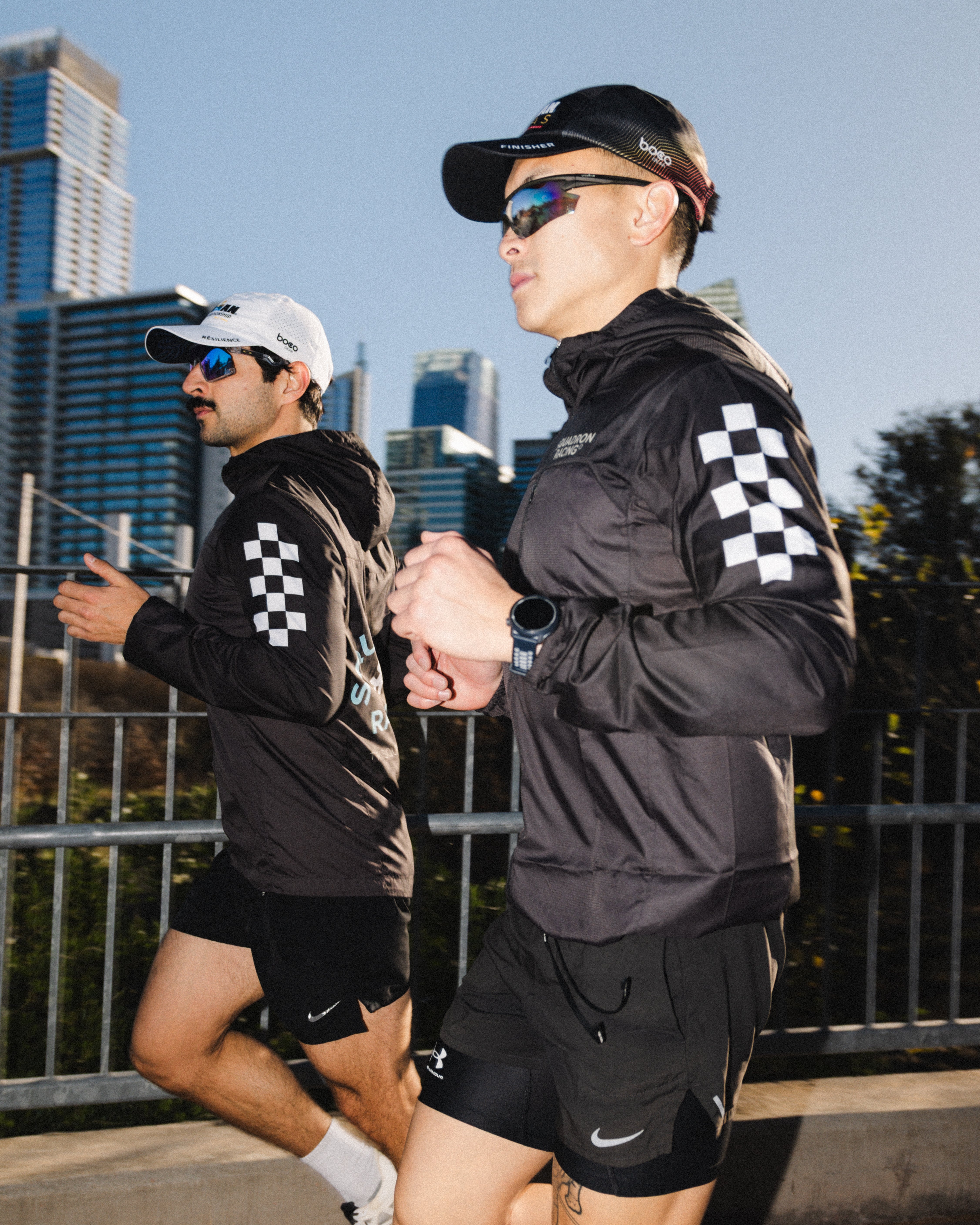 Squadron racing athletes running in wind jackets and ironman triathlon hats.