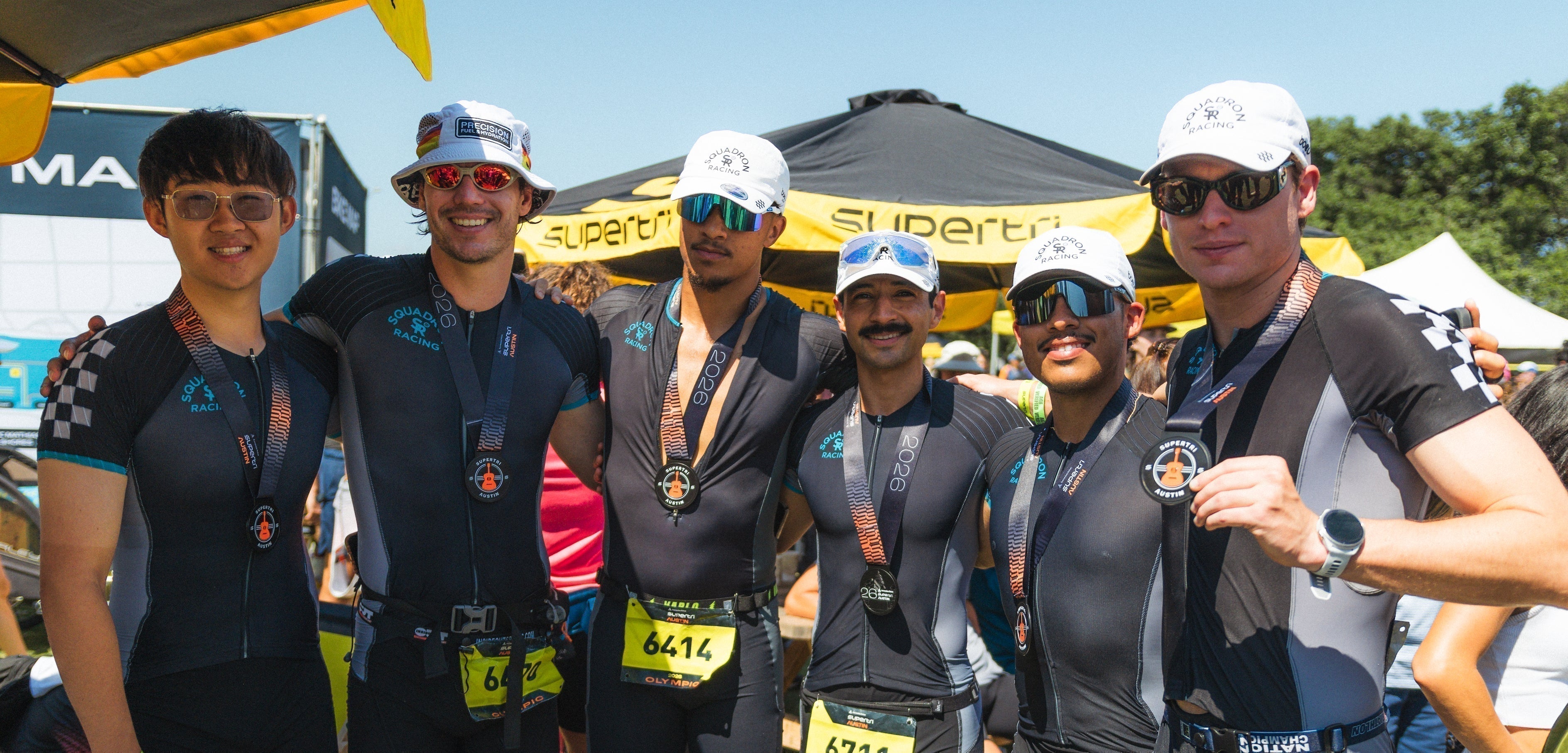 Squadron Racing Athletes celebrating a race finish with their medals. 