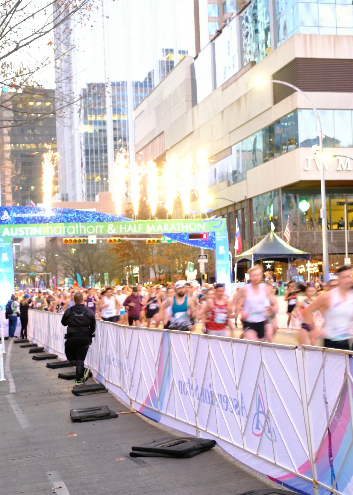 The start line at the Austin Marathon with all the runners sprinting through. 