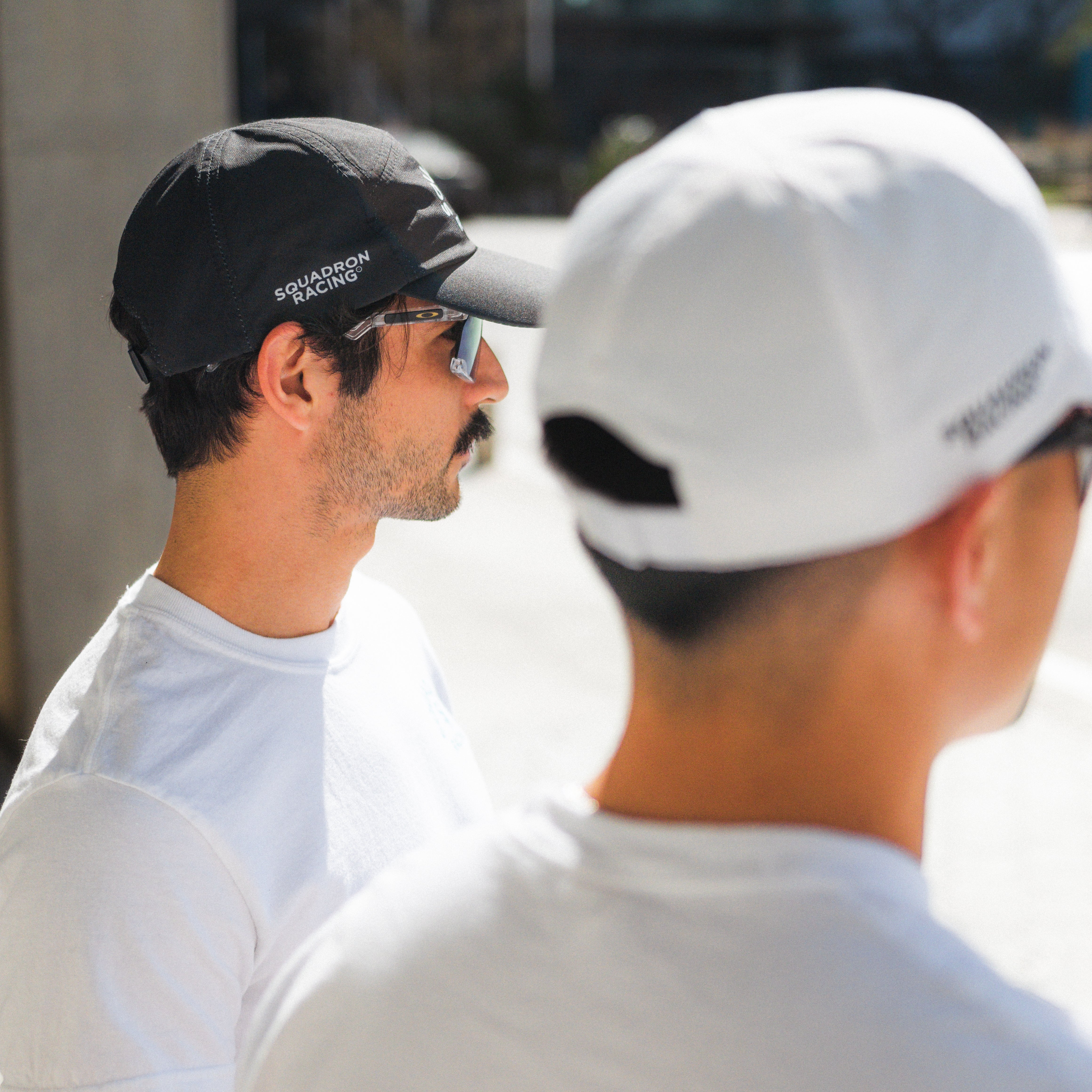 Two squadron racing athletes in hats getting ready to go running. 